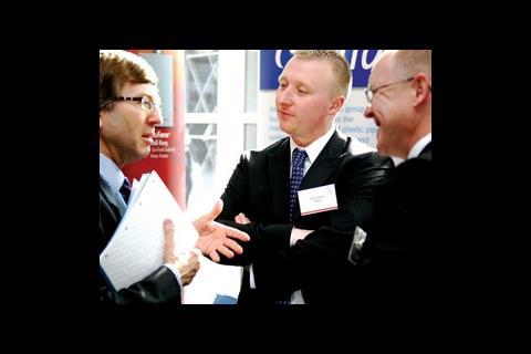 Andrew Saville (left), a consultant from Essex, swaps ideas with delegates from Aliaxis, one of the conference sponsors